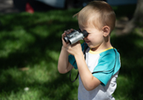 Boy looking for birds through binoculars