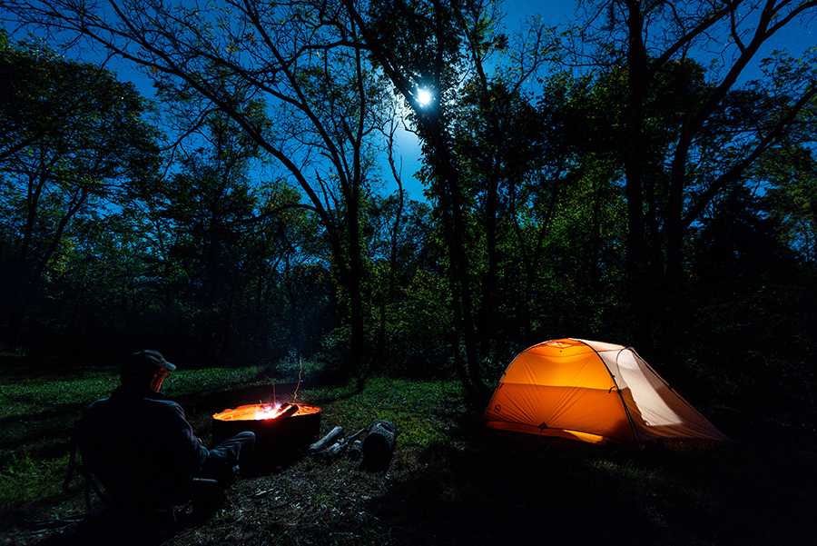 Man camping at Indian Cave State Park under a full moon.