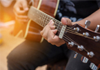 Closeup of man playing acoustic guitar