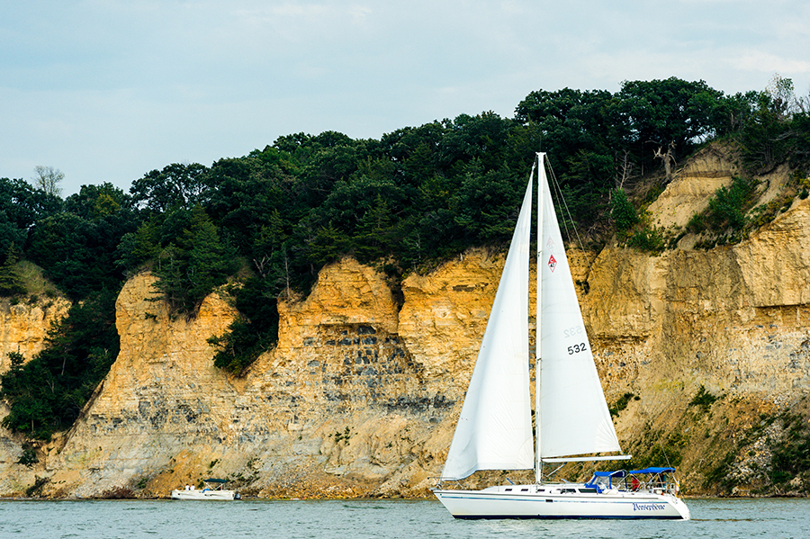 A sailboat on Lewis and Clark Lake by bluffs.