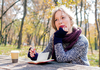 Woman journaling at a park bench