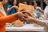 Someone giving another person a bag of food