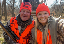 Father and daughter smiling together during a firearm deer hunt