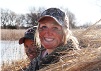 Young hunters smiling during a Canada goose hunt in a wetland