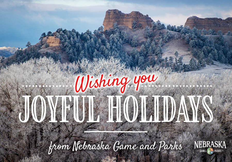 Wishing you joyful holidays from Nebraska Game and Parks - Frosty bluffs and trees in western Nebraska with text