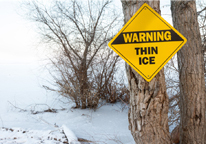 Warning sign of "Thin Ice" on a tree 