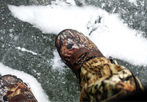 Closeup view of someone wearing boots while ice fishing