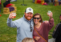 Couple holding up wine glasses at Sip Nebraska