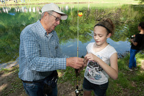 Youth fishing instructor helping a young angler