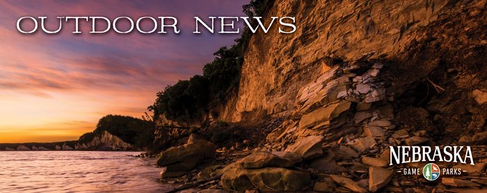Rocky shoreline at a Nebraska state park with sunset in background, and text "Outdoor News" with Game and Parks logo