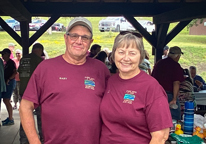 Husband and wife, Liz and Gary Doerr, posing at Niobrara State Park in matching volunteer T-shirts