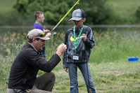 Youth fishing instructor helping a child fish