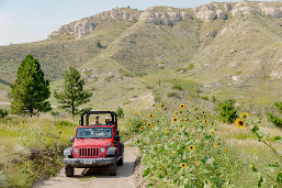 The RV There Yet? hosts riding through a Nebraska state park in a Jeep