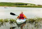 Woman kayaking at a Nebraska state park with a big smile