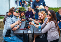 Group of friends at Sip Nebraska, holding up wine glasses at a picnic table