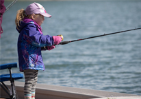 Girl fishing from a pier at a state park fishing derby
