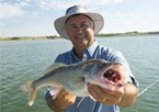 Angler holding up a walleye and smiling