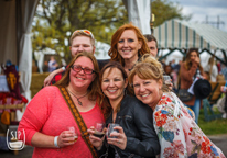 Group of girlfriends holding wine glasses and smiling at Sip Nebraska