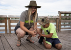 Naturalist helping a boy fish at a Community Fishing Event