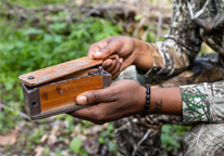 Closeup of a turkey hunter using a box call