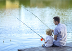 Father and son fishing from a dock