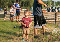 Boy with his dad at a fishing event along the shore