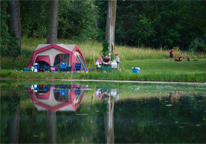 Tent pitched alongside a lake at Louisville State Recreation Area