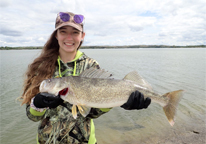 Female angler holding up a large walleye