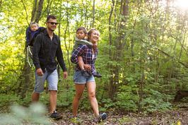 Family hiking in the woods and smiling