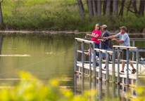 People fishing from a dock at Fort Robinson State Park in June