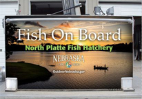 Large image of fishing boat on side of hatchery truck with text "Fish On Board"