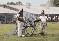 Reenactors prepare to fire a cannon at Fort Atkinson