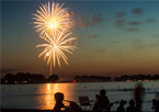 Fireworks reflect over a lake