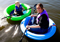 Mother and son floating in round rafts on a lake