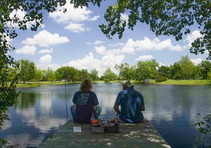 View from behind of two anglers fishing at a lake