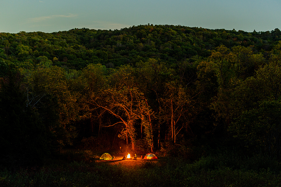 Expansive view of a campfire lighting up the tree-filled surroundings of Indian Cave State Park.