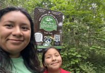 Mother and daughter pose by a Your Parks Adventure selfie sign