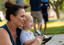 Mom helping young son to fish