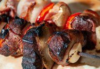 Canada goose grilled with onions, bell peppers and bacon on a skewer.