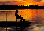 Silhouette of an angler fishing from a pier at sunset at Willow Creek State Recreation Area