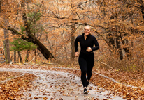 Woman running on a trail at Schramm Park State Recreation Area in fall