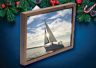 A framed image of a sailboat on a holiday background