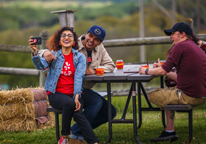 A woman takes photos of herself and her friends at Sip Nebraska