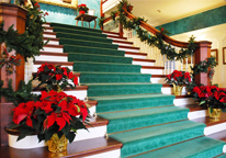 Poinsettias decorate a grand staircase at Arbor Lodge Mansion