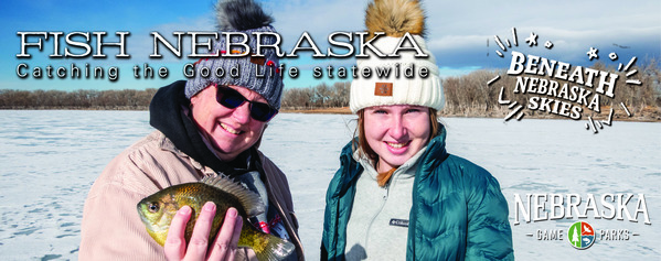 Father and daughter holding up a fish caught through the ice