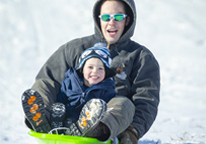 A father and son sledding at a Nebraska state park