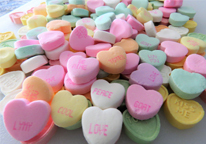 Heart-shaped conversation candies laying in a small pile