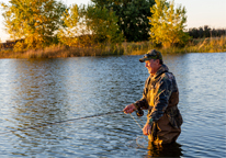 An angler fishing in a lake in fall