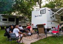 People sitting around a camper