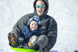 A father and son sledding at Mahoney State Park
